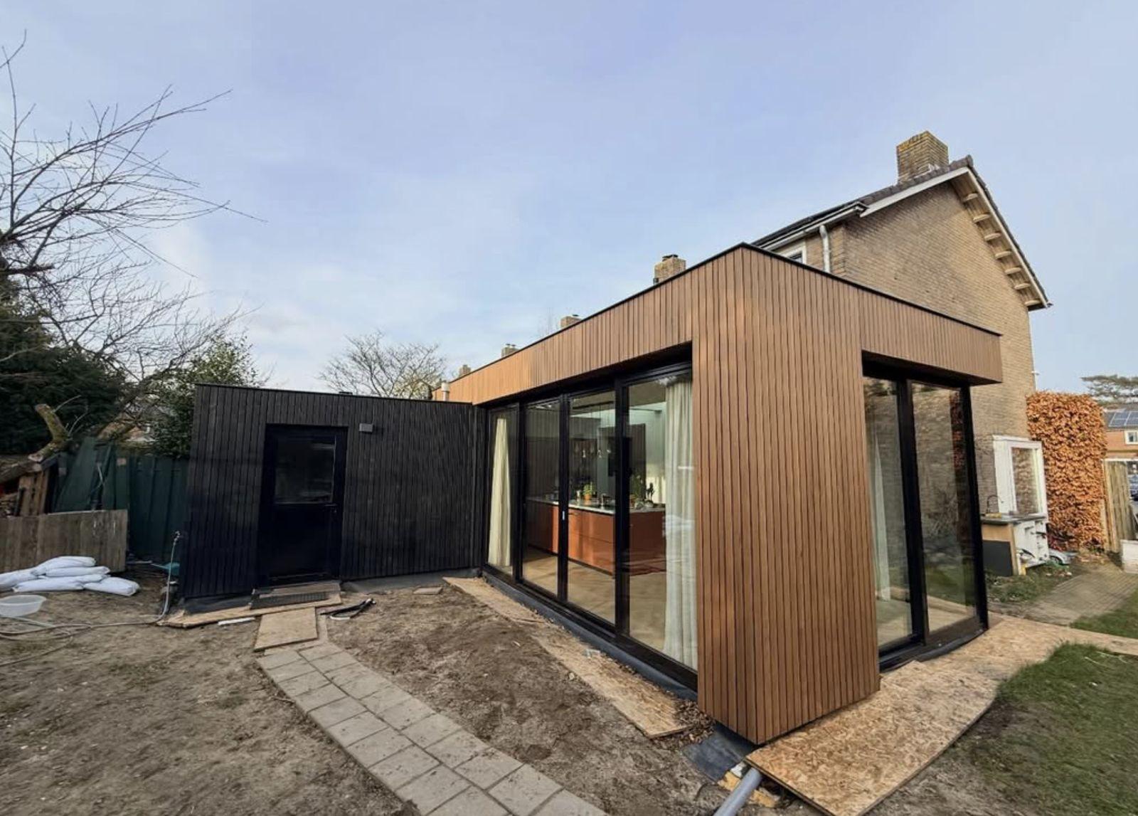 Moderne houten aanbouw met grote glaspui, gerealiseerd door Projectbouw Aannemers B.V.
