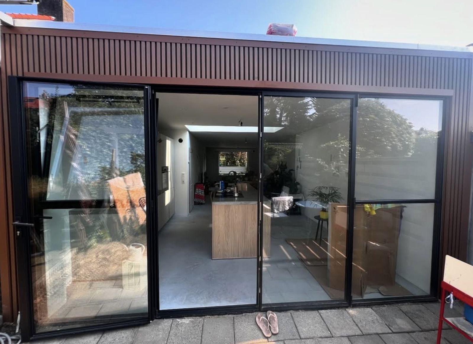 Uitbouw met stalen pui en open keuken, gerealiseerd door Projectbouw Aannemers B.V.