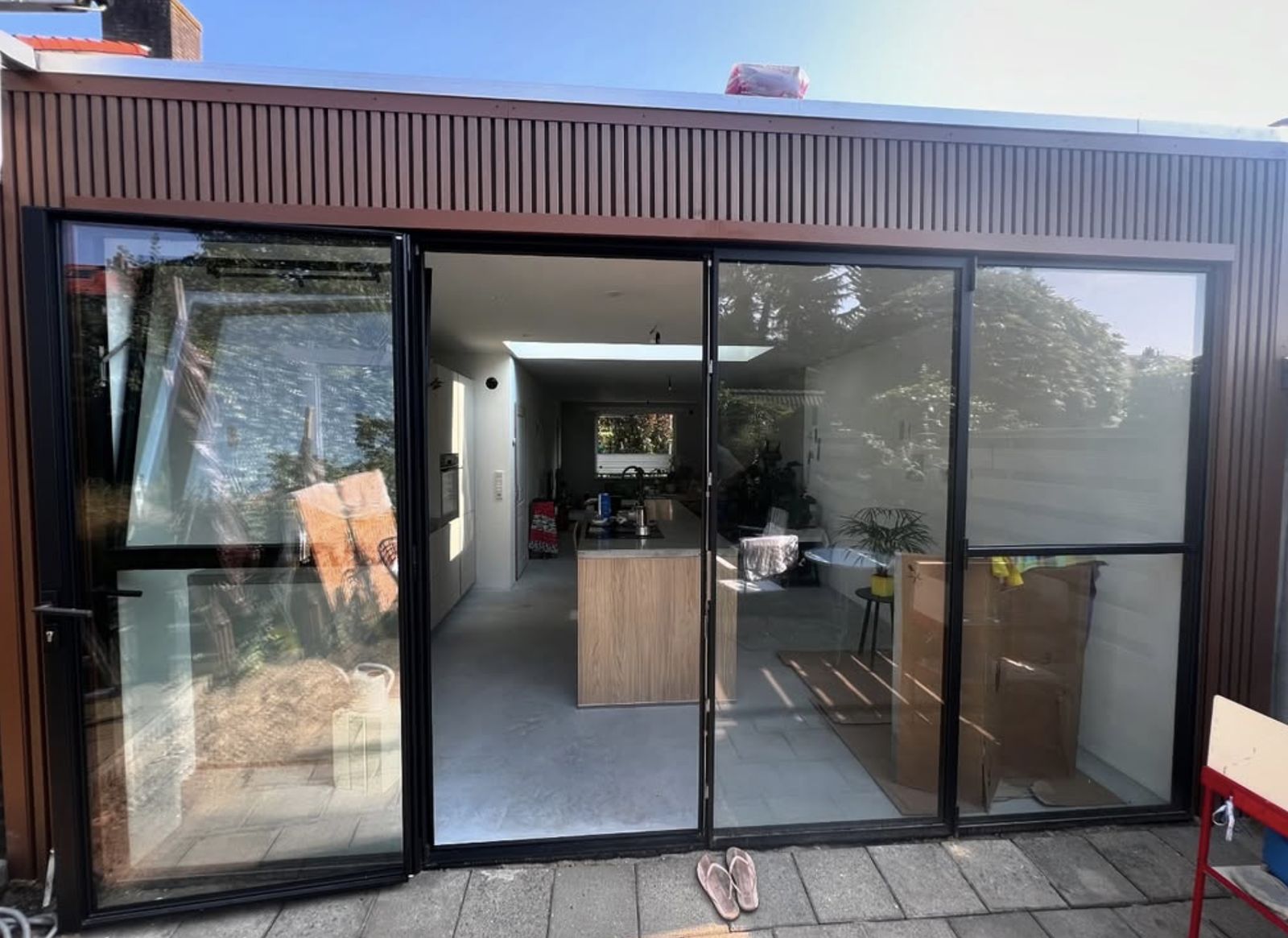 Uitbouw met stalen pui en zicht op de nieuwe open keuken