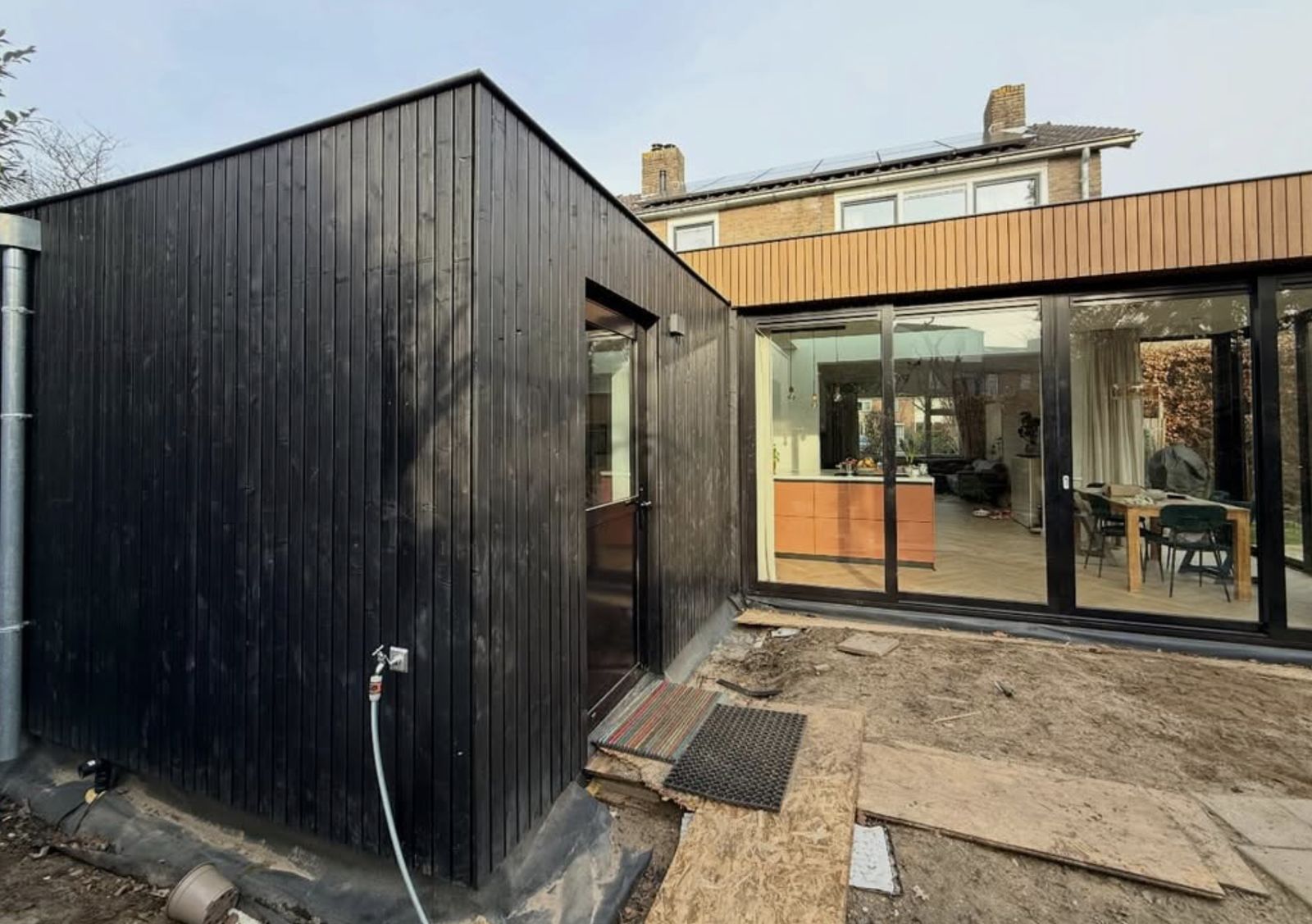 Aanbouw met openslaande glaspui en zicht op de keuken
