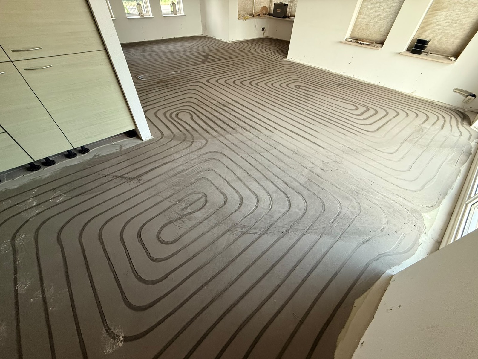 Woonkamer met afgewerkte dekvloer over de vloerverwarming
